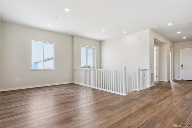 spare room with recessed lighting, baseboards, and wood finished floors