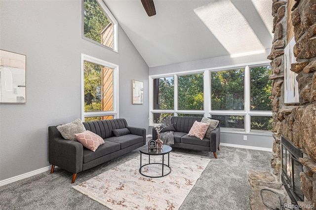 living room with high vaulted ceiling, carpet, ceiling fan, and a stone fireplace