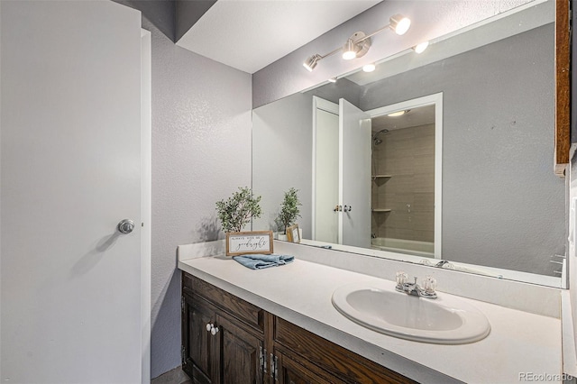 bathroom featuring vanity and tiled shower / bath