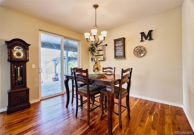 dining space with an inviting chandelier and dark hardwood / wood-style floors