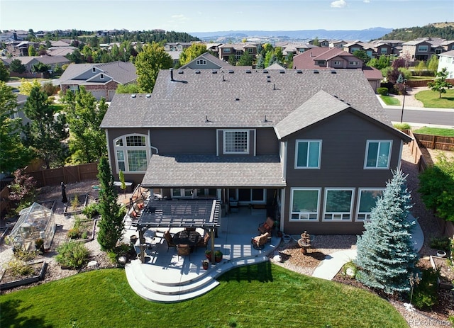 rear view of house with a pergola, a mountain view, a yard, and a patio area