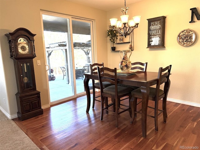 dining area featuring a notable chandelier, baseboards, and dark wood-style flooring