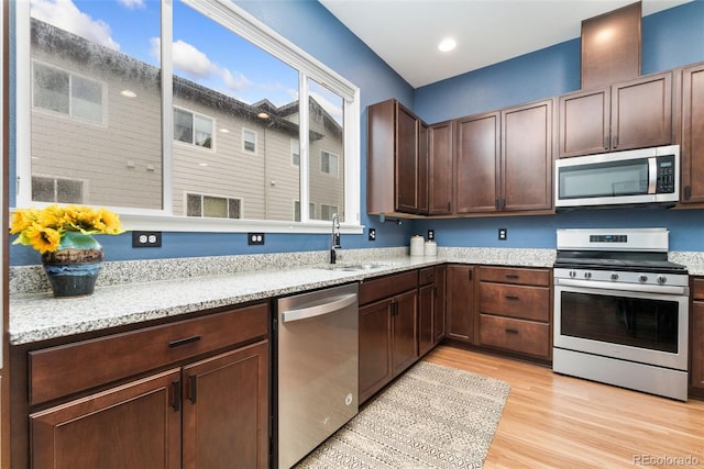 7808 W 43rd Pl, Wheat Ridge, CO 80033 - kitchen featuring stainless steel appliances, a sink, light wood-type flooring, light stone counters, and recessed lighting