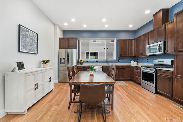 7808 W 43rd Pl, Wheat Ridge, CO 80033 - kitchen featuring appliances with stainless steel finishes, light wood finished floors, dark brown cabinets, recessed lighting, and a sink