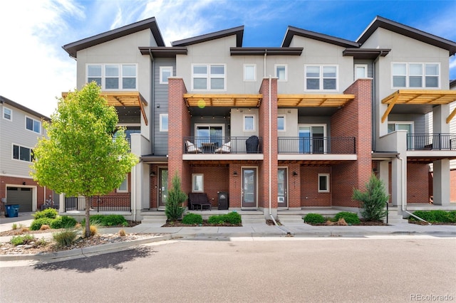 7808 W 43rd Pl, Wheat Ridge, CO 80033 - view of front of property featuring stucco siding, a balcony, and brick siding
