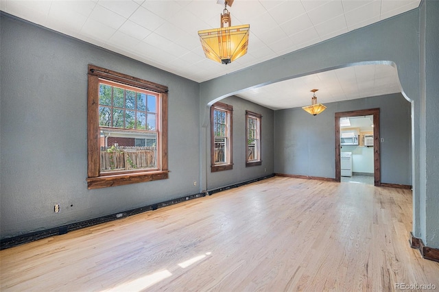 4635 Teller St, Wheat Ridge, CO 80033 - spare room featuring arched walkways, wood finished floors, and baseboards