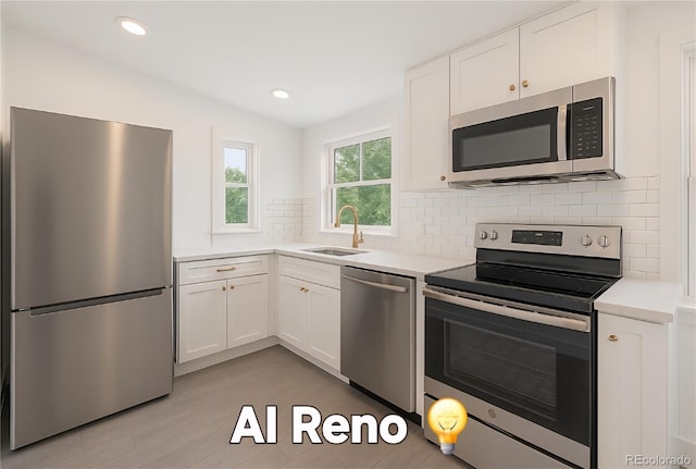 4635 Teller St, Wheat Ridge, CO 80033 - kitchen featuring stainless steel appliances, a sink, white cabinets, light countertops, and recessed lighting