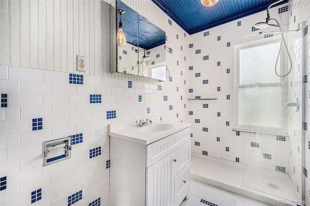 4635 Teller St, Wheat Ridge, CO 80033 - bathroom featuring a shower stall, vanity, tile patterned flooring, and tile walls