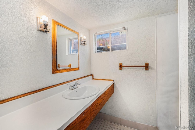 4635 Teller St, Wheat Ridge, CO 80033 - bathroom featuring tile patterned floors, a textured ceiling, vanity, a textured wall, and baseboards