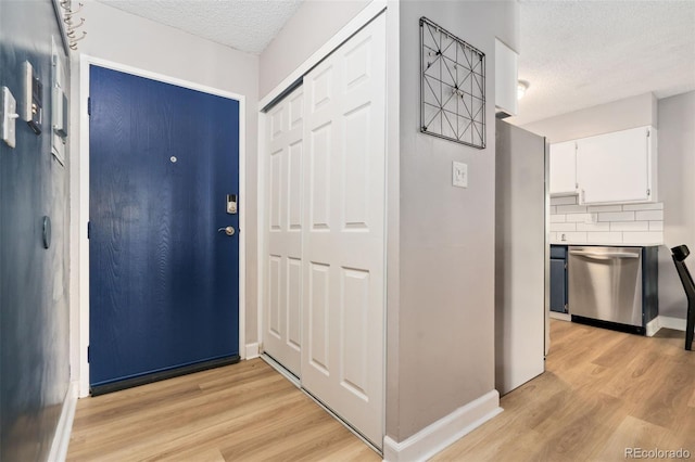 7040 E Girard Ave Unit 207, Denver, CO 80224 - foyer featuring a textured ceiling, light wood-type flooring, and baseboards