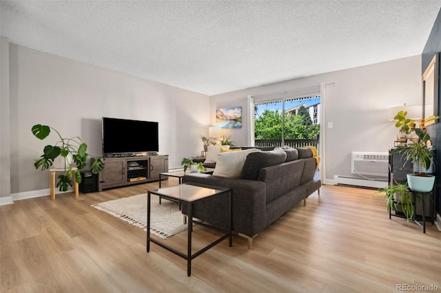7040 E Girard Ave Unit 207, Denver, CO 80224 - living area featuring light wood-style floors, a textured ceiling, a baseboard radiator, baseboards, and a wall mounted air conditioner