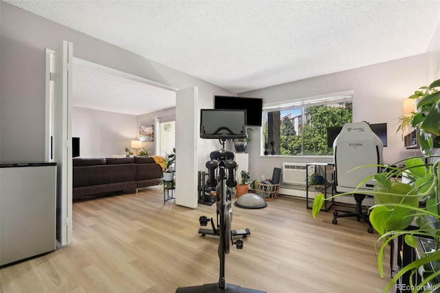 7040 E Girard Ave Unit 207, Denver, CO 80224 - exercise area featuring light wood-style floors and a textured ceiling