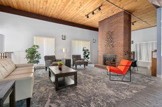 7040 E Girard Ave Unit 207, Denver, CO 80224 - carpeted living room featuring track lighting, wood ceiling, a brick fireplace, and a high ceiling