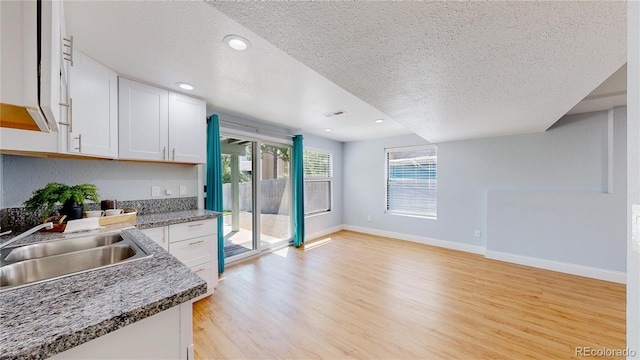 3883 S Fraser St, Aurora, CO 80014 - kitchen featuring a textured ceiling, white cabinets, light wood-style flooring, and recessed lighting