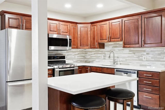 kitchen featuring sink, backsplash, stainless steel appliances, and a breakfast bar