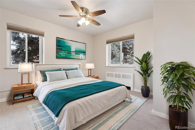bedroom featuring light carpet, radiator heating unit, and ceiling fan