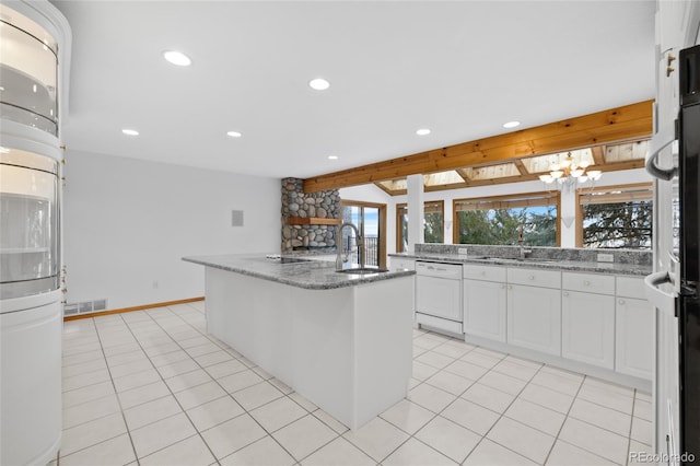 kitchen featuring white dishwasher, white cabinets, sink, and a kitchen island with sink