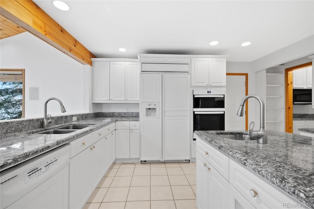 kitchen with white cabinetry, sink, white dishwasher, and paneled built in refrigerator