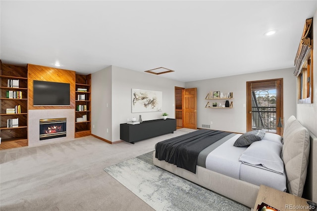 bedroom with access to outside, light carpet, and wood walls