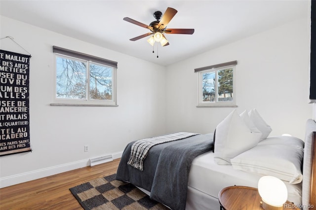 bedroom with a ceiling fan, baseboards, visible vents, and wood finished floors