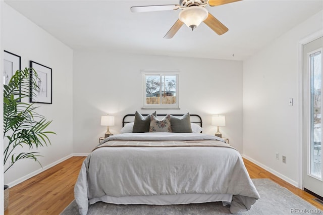 bedroom featuring a ceiling fan, baseboards, and wood finished floors