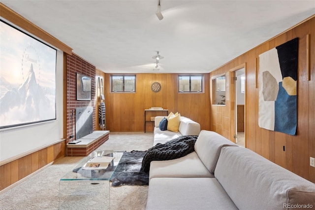 living room with wooden walls, a fireplace, and carpet flooring