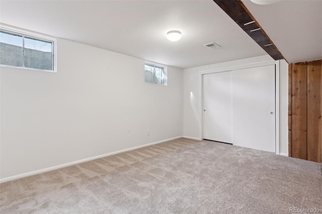 basement featuring carpet floors, visible vents, and baseboards