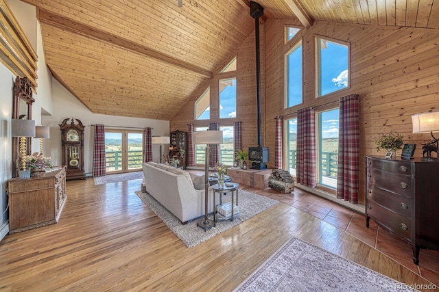 895 Acorn Rd, Cotopaxi, CO 81223 - living room with a wood stove, high vaulted ceiling, a wood ceiling with exposed beams, wooden walls, and hardwood / wood-style floors