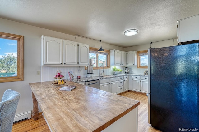 895 Acorn Rd, Cotopaxi, CO 81223 - kitchen with freestanding refrigerator, a baseboard heating unit, a peninsula, stainless steel dishwasher, and white cabinets