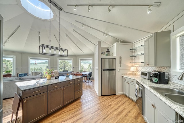 895 Acorn Rd, Cotopaxi, CO 81223 - kitchen with appliances with stainless steel finishes, rail lighting, open floor plan, light wood finished floors, and decorative backsplash
