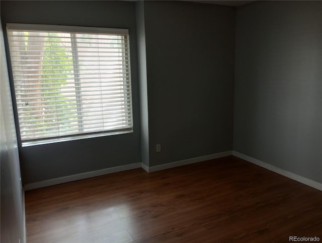 empty room featuring wood finished floors and baseboards