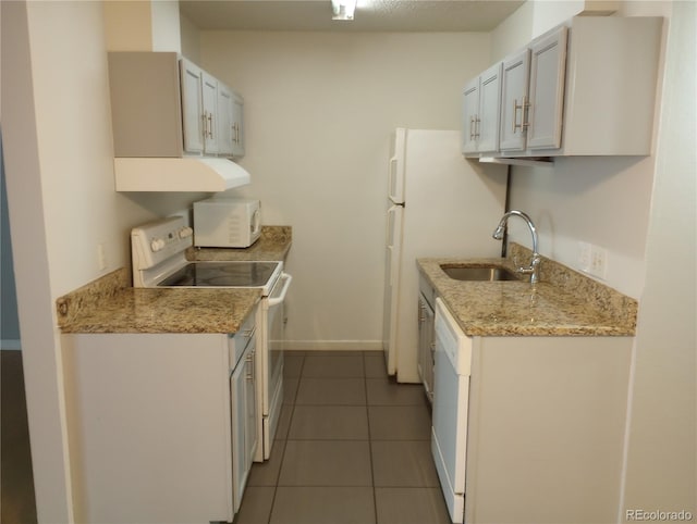 kitchen with white appliances, a sink, tile patterned flooring, baseboards, and under cabinet range hood
