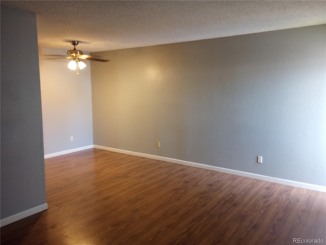 empty room with a ceiling fan, dark wood finished floors, and baseboards