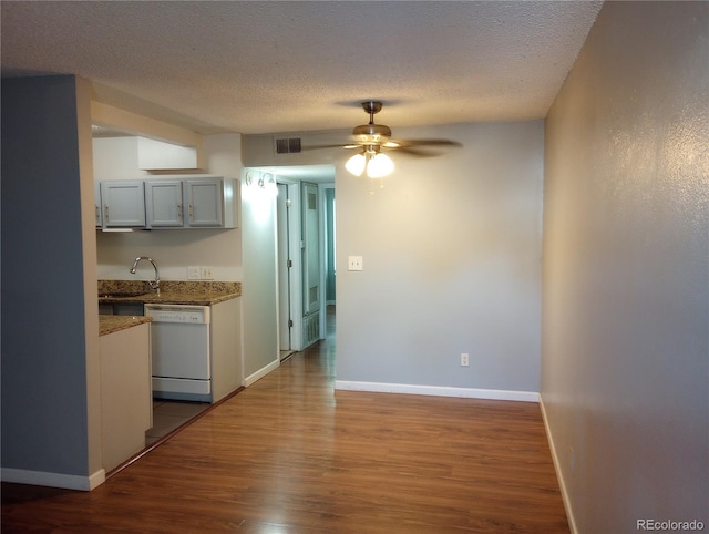 kitchen with white dishwasher, wood finished floors, ceiling fan, a textured ceiling, and gray cabinetry