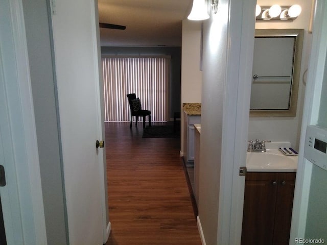 hallway featuring a sink and dark wood-type flooring