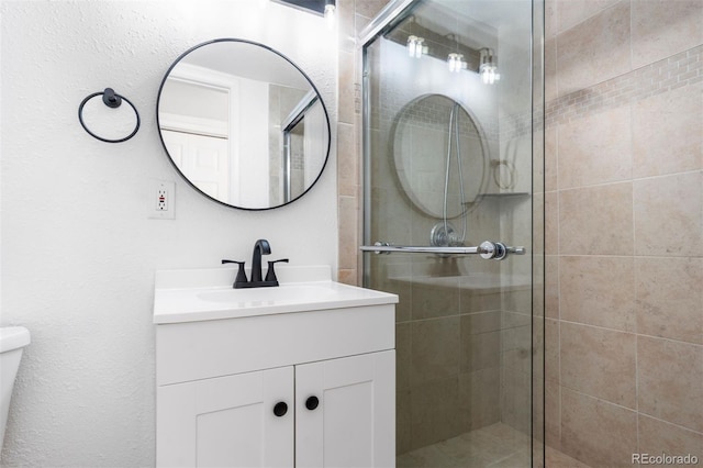 full bath featuring toilet, a shower stall, and vanity