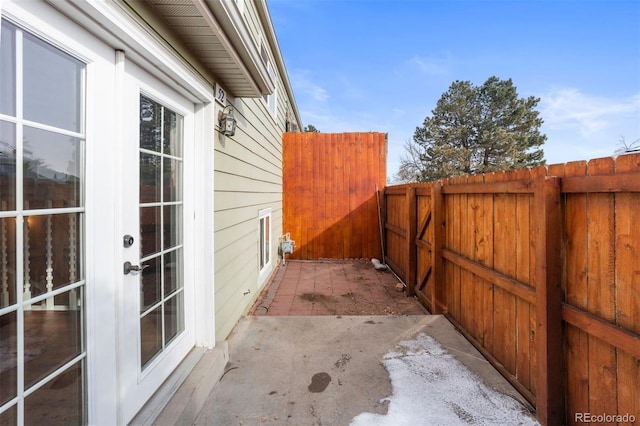 view of side of property with a patio area, fence, and french doors