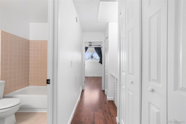 corridor featuring baseboards and dark wood finished floors