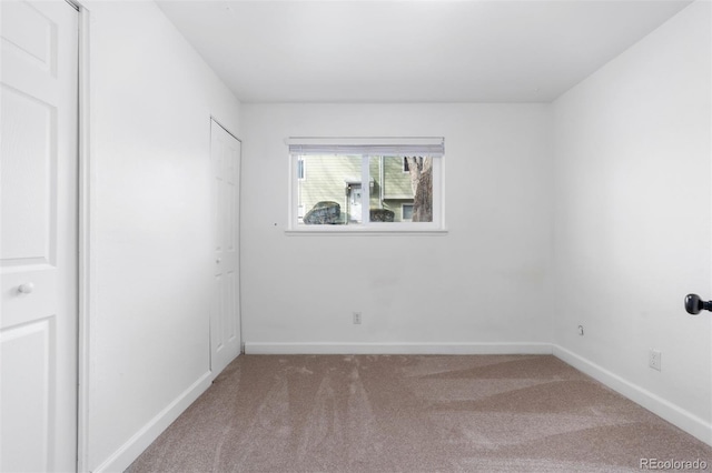 unfurnished room with carpet and baseboards