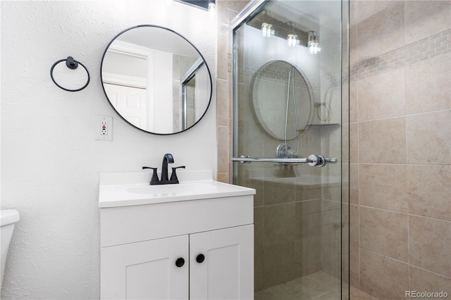 bathroom featuring toilet, a shower stall, and vanity