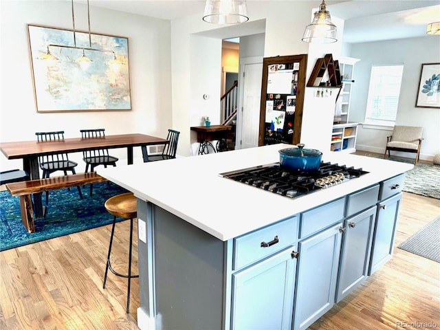 2831 Shadow Lake Rd, Lafayette, CO 80026 - kitchen with stainless steel gas cooktop, light wood-type flooring, pendant lighting, baseboards, and light countertops