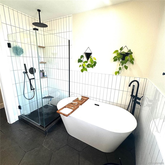 2831 Shadow Lake Rd, Lafayette, CO 80026 - bathroom featuring a shower stall, tile walls, a freestanding tub, and tile patterned flooring