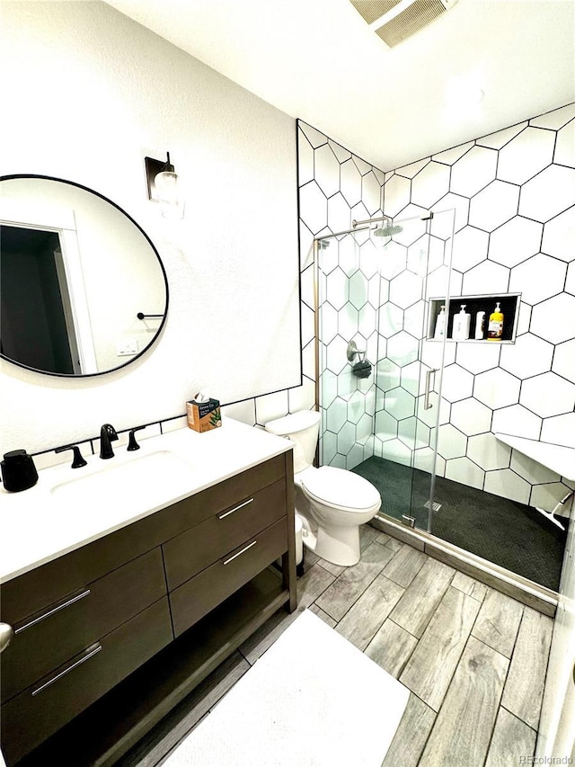 2831 Shadow Lake Rd, Lafayette, CO 80026 - bathroom with vanity, a stall shower, wood finished floors, toilet, and tile walls