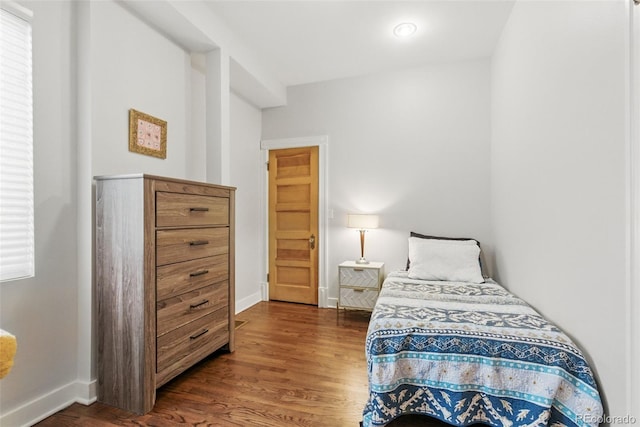 bedroom with baseboards and wood finished floors