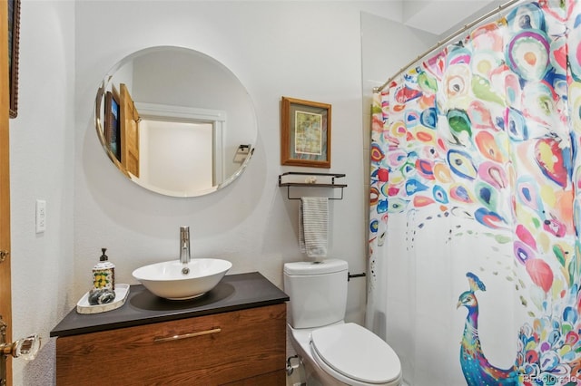 bathroom with toilet, vanity, and curtained shower