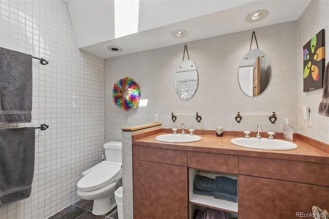 full bathroom featuring tile patterned floors, double vanity, a sink, and toilet