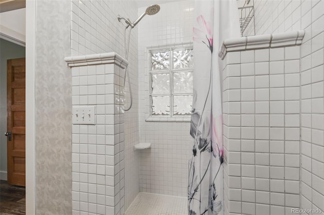 bathroom featuring a tile shower and wood finished floors