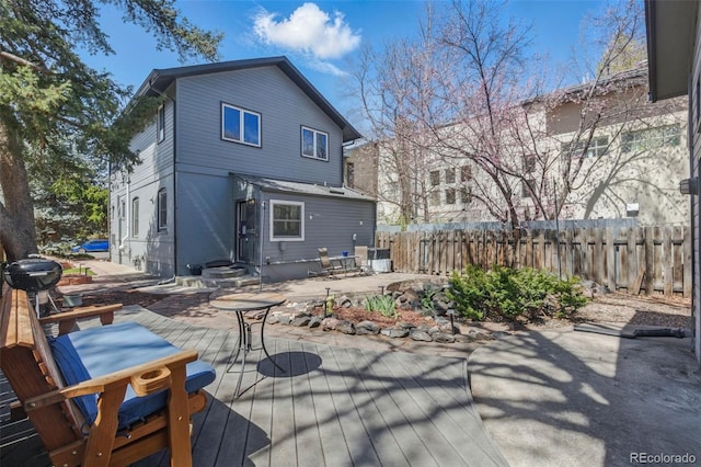 back of property featuring entry steps, an outdoor fire pit, fence, and a wooden deck