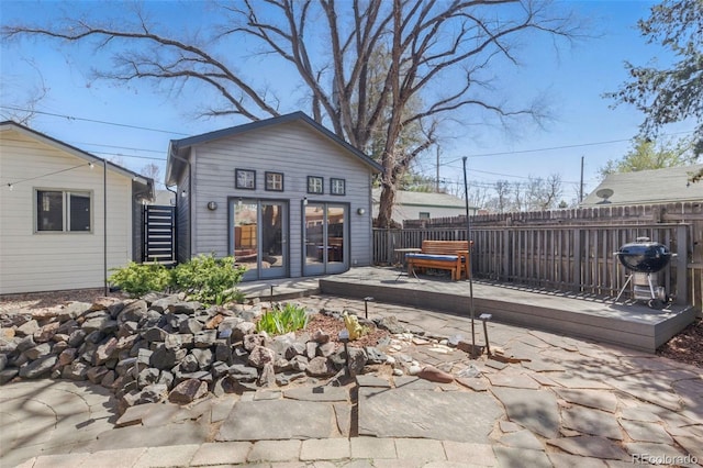rear view of property with french doors and fence