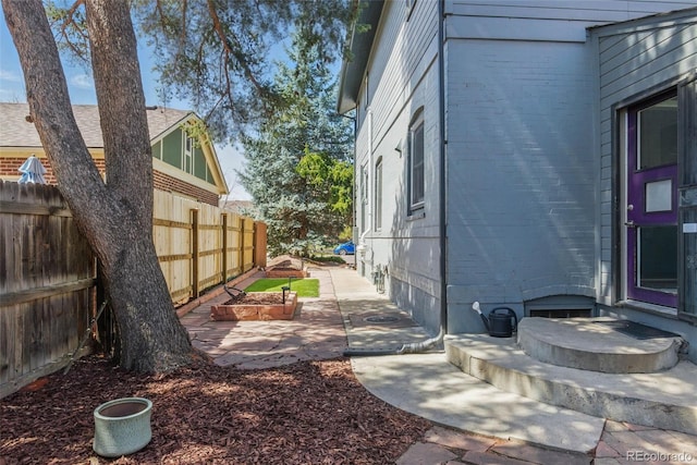 view of home's exterior featuring brick siding and fence